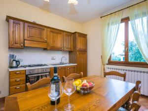 una cucina con tavolo in legno e bicchieri da vino di Holiday Home Ginestra by Interhome a Badia Agnano