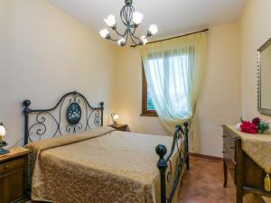a bedroom with a bed and a dresser and a window at Holiday Home Ginestra by Interhome in Badia Agnano