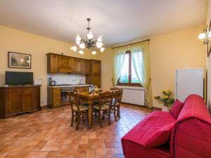 Badia AgnanoにあるHoliday Home Ginestra by Interhomeのキッチン、ダイニングルーム(テーブル、赤いソファ付)