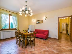 un soggiorno con tavolo e divano rosso di Holiday Home Ginestra by Interhome a Badia Agnano