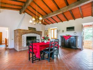 a dining room with a red table and chairs and a fireplace at Apartment Fattoria Petraglia - Padronale by Interhome in Monteriggioni