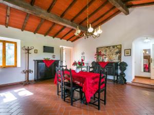 a dining room with a red table and chairs at Apartment Fattoria Petraglia - Padronale by Interhome in Monteriggioni