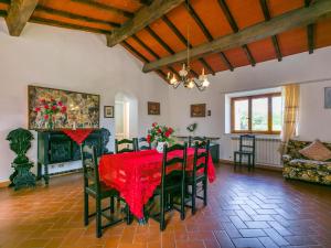 a dining room with a red table and chairs at Apartment Fattoria Petraglia - Padronale by Interhome in Monteriggioni