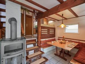 uma sala de estar com um fogão a lenha e uma mesa em Holiday Home Sigi by Interhome em Frankenau