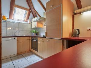 a kitchen with wooden cabinets and a counter top at Holiday Home Sigi by Interhome in Frankenau +16 photos