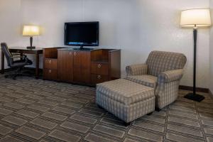 a hotel room with a chair and a tv at Travelodge by Wyndham Appleton in Appleton