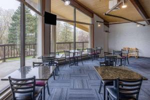 a dining room with tables and chairs and windows at Travelodge by Wyndham Appleton in Appleton