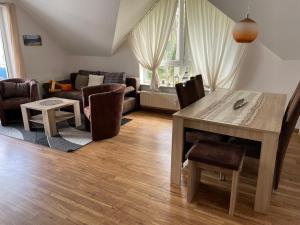 een woonkamer met een tafel en stoelen en een bank bij Apartment Blaumuschel - LUB118 by Interhome in Lubmin