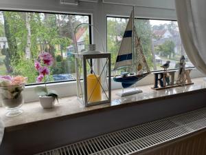 een vensterbank met beeldjes en een zeilboot erop bij Apartment Blaumuschel - LUB118 by Interhome in Lubmin