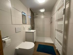 een witte badkamer met een toilet en een wastafel bij Apartment Blaumuschel - LUB118 by Interhome in Lubmin