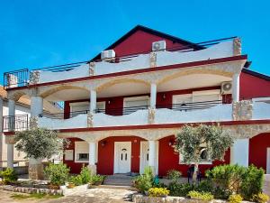 a red and white building with a balcony at Apartment Josip - VOD199 by Interhome in Tribunj