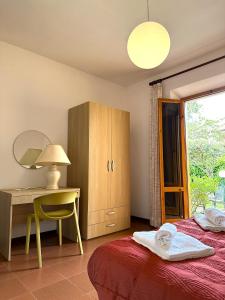 a bedroom with a bed and a desk and a mirror at Appartamenti Portiglioni-Cipressi in Puntone di Scarlino