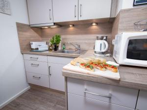 a kitchen with a counter with a sandwich on a cutting board at Apartment Sanddüne by Interhome in Norddeich