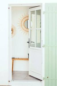 une porte blanche menant à une pièce avec un soleil sur le mur. dans l'établissement Maison 3 chambres plus 1 studio indépendant, à Sainte-Marie de Ré