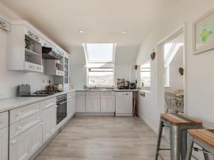 a kitchen with white cabinets and a large window at Holiday Home Driftwood by Interhome in Shaldon