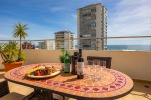 a table with wine glasses and food on a balcony at Cosy Penthouse Apartment with Large Terrace & Seaview in Quarteira