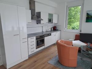 a kitchen with white cabinets and a couch and a table at Apartment Vinzek by Interhome in Töschling
