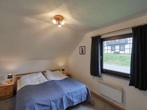 a bedroom with a blue bed and a window at Apartment Grandpa by Interhome in Frankenau
