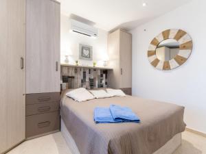 a bedroom with a large bed and a mirror at Apartment Sant Maurici-22 by Interhome in Empuriabrava