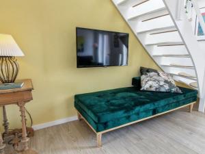 uma sala de estar com um sofá e uma televisão na parede em Apartment Jasna - 2-3km from the sea in Western Jutland by Interhome em Sønderby
