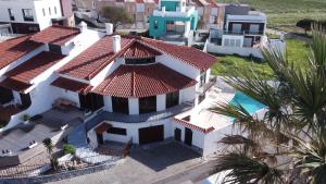 une vue aérienne sur une maison blanche avec un toit rouge dans l'établissement House of PAB, à Praia da Areia Branca