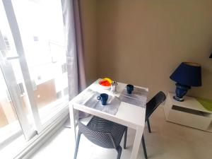 a white table with chairs and a lamp and a window at New apartment Alcala 1 room & FREE WIFI in Alcalá