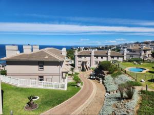 ariale Aussicht auf ein Haus mit dem Ozean im Hintergrund in der Unterkunft Pinnacle Point Golf Estate - Golf Villa 10-1 in Mossel Bay