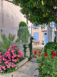 a garden with pink flowers and a fence at Le gîte de Sainte Valière PISCINE,SPA et CLIMATISATION in Sainte-Vallière