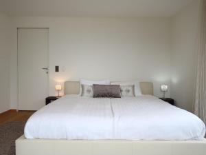 a large white bed in a bedroom with two lamps at Apartment L'Esplanade A3-8 by Interhome in Montreux