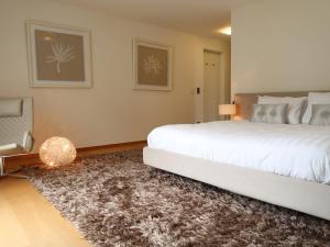 a bedroom with a large white bed and a rug at Apartment L'Esplanade A3-8 by Interhome in Montreux +32 photos
