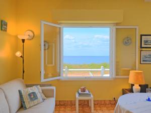 a living room with a window with a view of the ocean at Holiday Home Charme de la plage du Moulin by Interhome in Mesquer