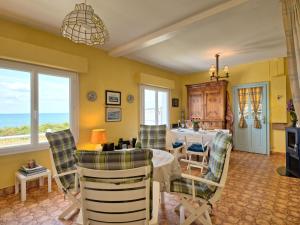 a dining room with a table and chairs and the ocean at Holiday Home Charme de la plage du Moulin by Interhome in Mesquer +26 photos