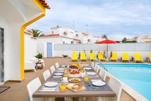 a table with food on it next to a swimming pool at Villa Nobre by The Portuguese Butler in Albufeira