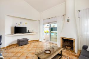 a living room with a fireplace and a tv at Villa Nobre by The Portuguese Butler in Albufeira