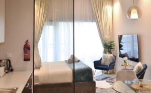 um quarto de hotel com uma cama e uma cozinha em Elegant Studio in park View JVC em Dubai