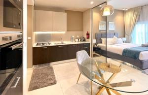 uma cozinha e um quarto com uma cama e uma mesa em Elegant Studio in park View JVC em Dubai