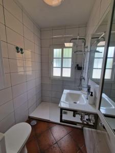 a bathroom with a sink and a toilet and a mirror at Apartamento cerca de la playa in Chiclana de la Frontera