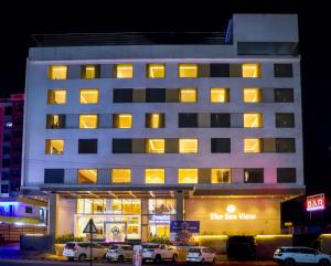 a hotel building with cars parked in front of it at Hotel The Sea View, Mangalore in Mangalore