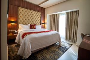 Una habitación de hotel con una cama grande y una ventana. en The Lilygate Lagos, en Lagos