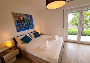 1 cama blanca grande en una habitación con ventana en Suite Apartment with a view and free parking, en Lugano