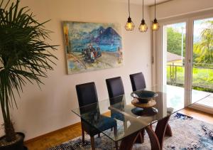 comedor con mesa de cristal y sillas en Suite Apartment with a view and free parking, en Lugano