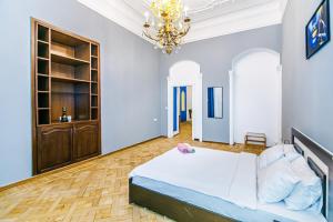 - une grande chambre avec un lit et un lustre dans l'établissement Apartment Nizami Street 5 room, à Baku