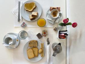 a table with two plates of bread and a cup of coffee at Anemoni Piraeus Hotel in Piraeus