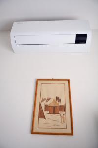 una luz de techo con una foto en una pared en Appartamento Climatizzato con Piscina Ca' Aurelia en Lido di Savio