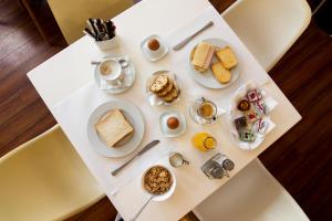 a white table with breakfast foods on it at Anemoni Piraeus Hotel in Piraeus