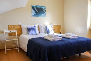 um quarto com uma cama com toalhas em Casa da Areia na Nazaré