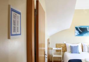 um quarto com uma cama e uma cadeira num quarto em Casa da Areia na Nazaré