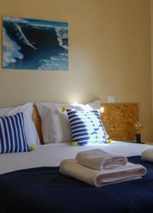 um quarto com uma cama com toalhas em Casa da Areia na Nazaré