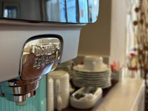 a close up of a kitchenaucet with dishes on a counter at Anemoni Piraeus Hotel in Piraeus