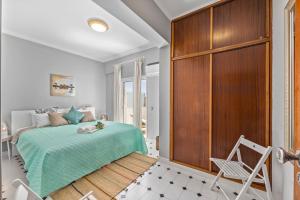 クアルテイラにあるCosy Penthouse Apartment with Large Terrace & Seaviewのベッドルーム1室(ベッド1台付)、木製キャビネットが備わります。